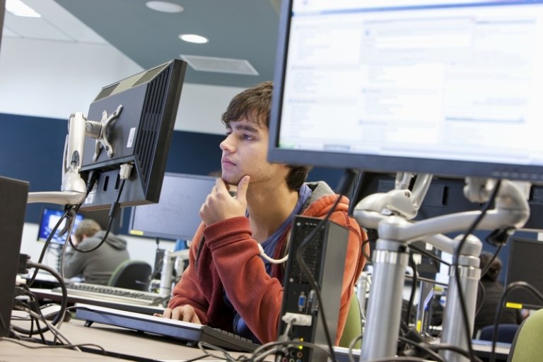 A student looks at a computer screen in a lab