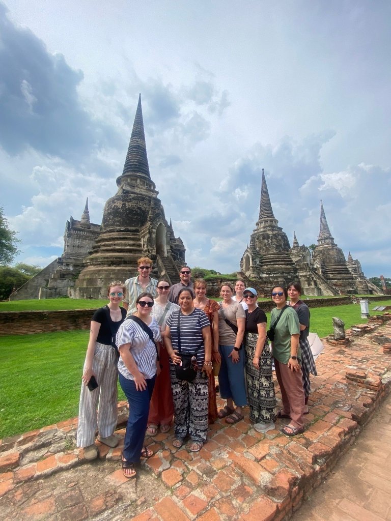 Students pose in front of foreign architecture on historical site