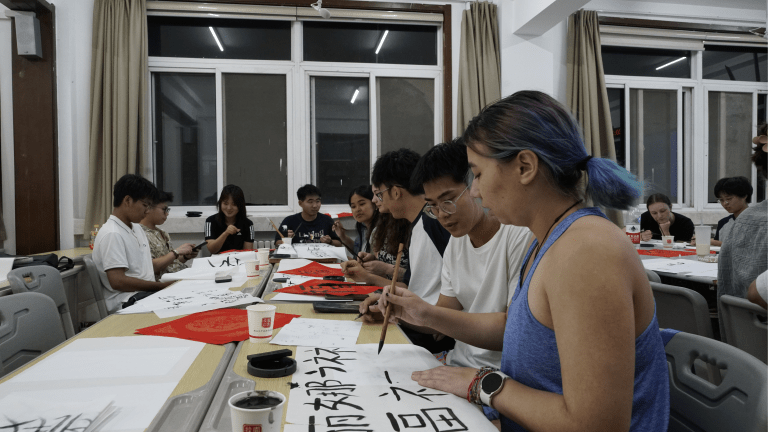 Students practice Chinese calligraphy