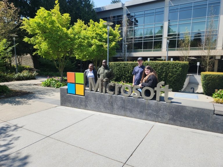 Students stand in front of Microsoft sign outside