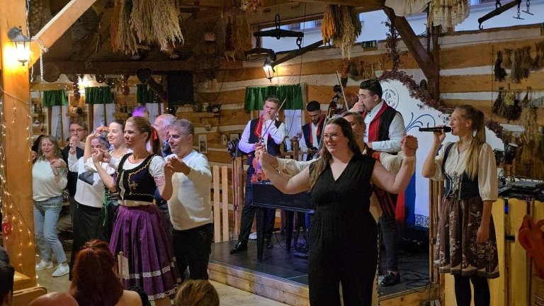 Students dance with people in traditional clothing