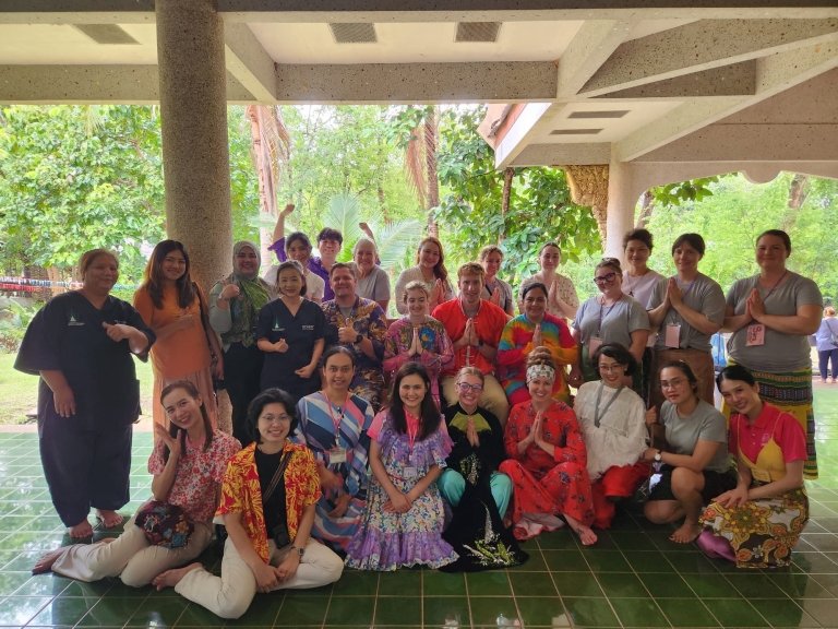 Students pose with a community of people
