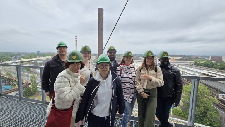 Students and faculty in hard hats on top of building