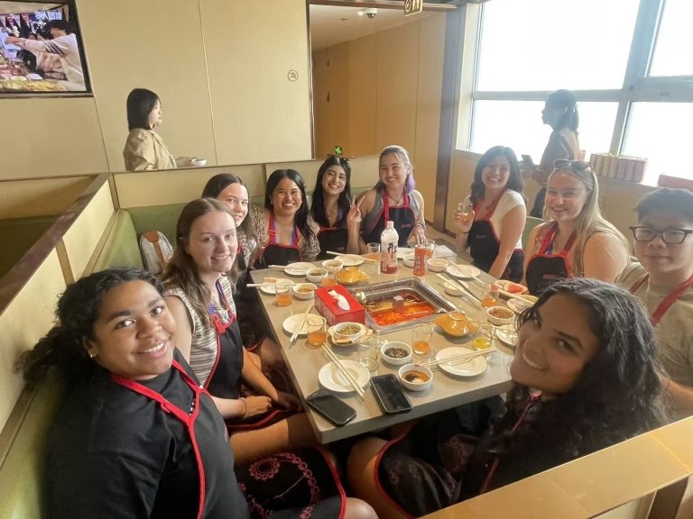 Students gather around a meal at a table