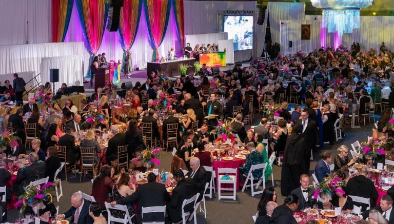 A crowd of people in black tie attire in decorated room