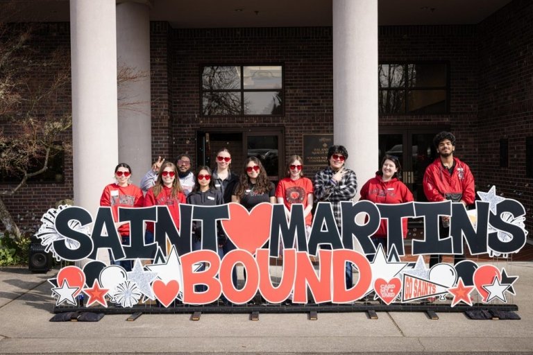 Students stand behind a large sign reading Saint Martin's Bound