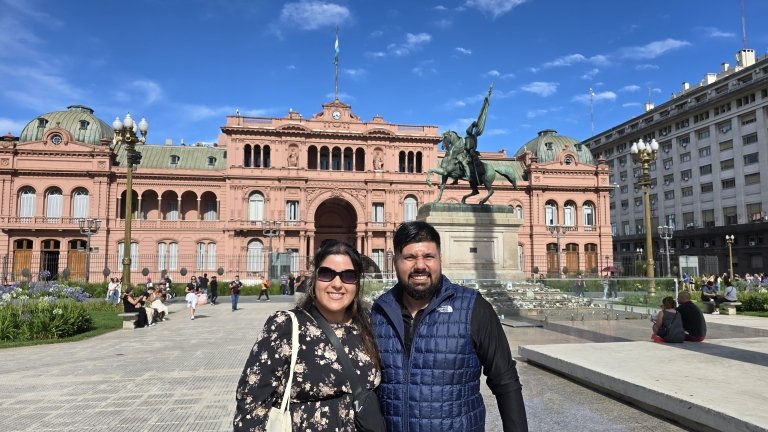 Two people stand in front of a building facade