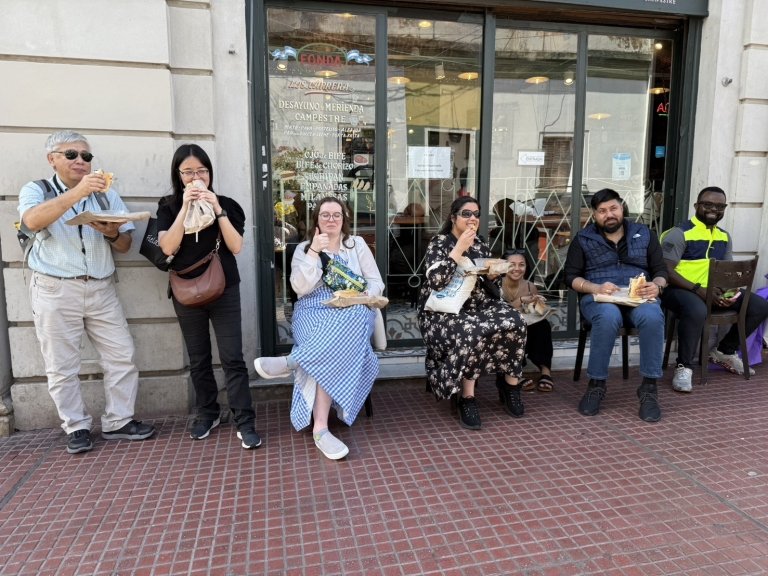 Students and faculty eat at a streetside cafe
