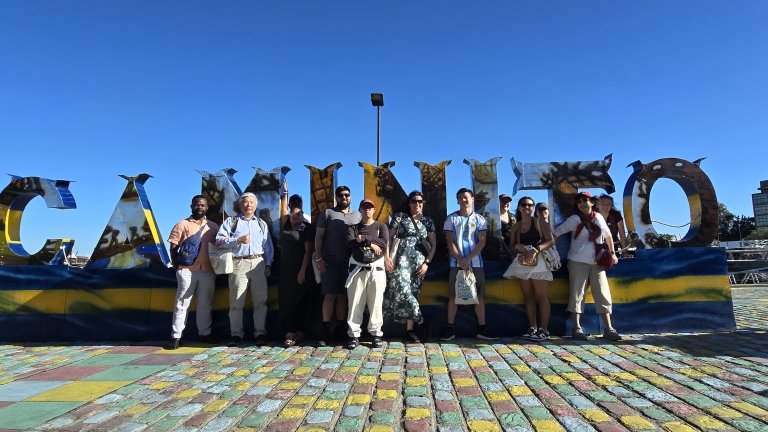 Students and faculty stand in front of large letters outside