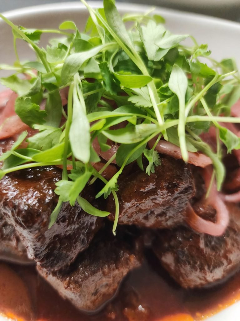 Close up of food, meat with greens on top