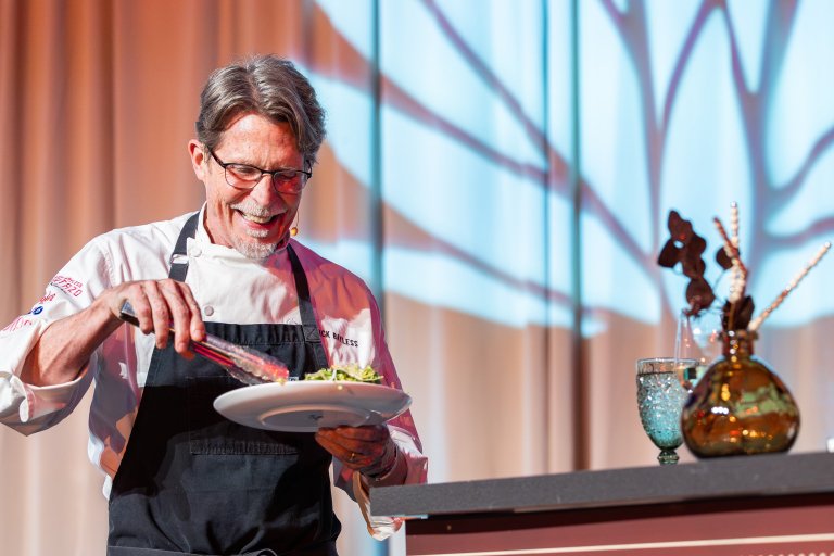 Rick Bayless plates food on stage