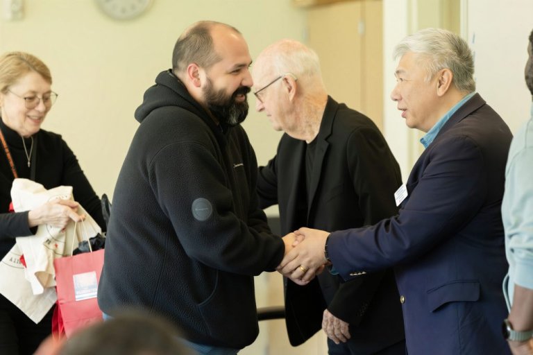 A student is congratulated by the team of judges