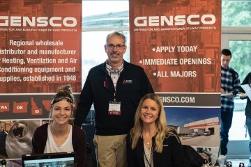 Three representatives of GENSCO pose at their booth at the Career Fair