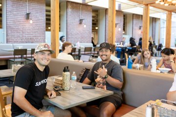 Students sit at tables in the dining hall
