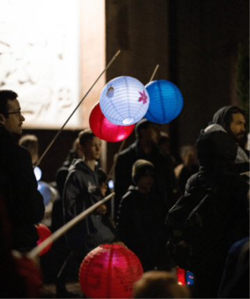 Handmade lanterns dangling at night with a group of people